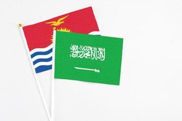 Saudi Arabia and Kiribati stick flags on white background. High quality fabric, miniature national flag. Peaceful global concept.White floor for copy space.