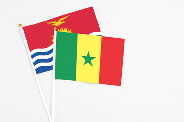 Senegal and Kiribati stick flags on white background. High quality fabric, miniature national flag. Peaceful global concept.White floor for copy space.