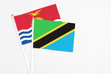Tanzania and Kiribati stick flags on white background. High quality fabric, miniature national flag. Peaceful global concept.White floor for copy space.