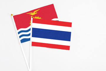 Thailand and Kiribati stick flags on white background. High quality fabric, miniature national flag. Peaceful global concept.White floor for copy space.