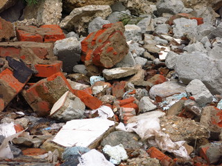 red broken bricks are lying in a heap on the road