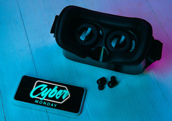 Top view of set of gadgets in purple neon light, blue background. Wireless earphones, smartphone,...