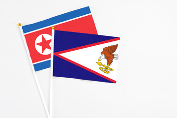 American Samoa and North Korea stick flags on white background. High quality fabric, miniature...