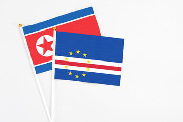 Cape Verde and North Korea stick flags on white background. High quality fabric, miniature national flag. Peaceful global concept.White floor for copy space.