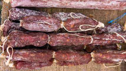 Closeup of a variety of cooked meats, salamis and sausages at a delicatessen