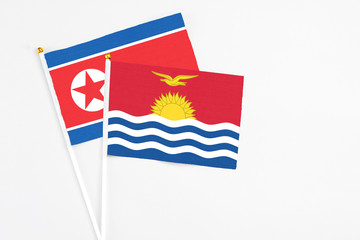 Kiribati and North Korea stick flags on white background. High quality fabric, miniature national flag. Peaceful global concept.White floor for copy space.
