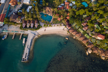 Aerial: Above  beachfront resort with sea view on beautiful tropical island koh Phangan, Haad Rin area 