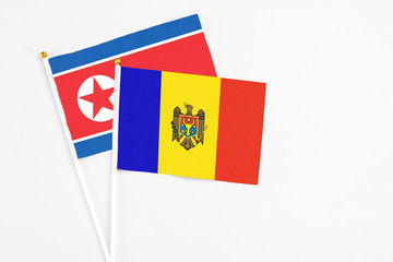 Moldova and North Korea stick flags on white background. High quality fabric, miniature national flag. Peaceful global concept.White floor for copy space.