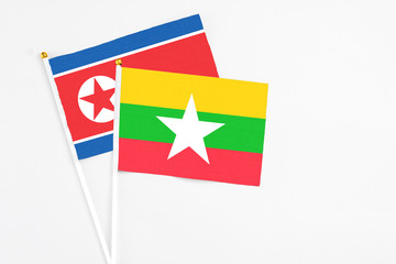 Myanmar and North Korea stick flags on white background. High quality fabric, miniature national flag. Peaceful global concept.White floor for copy space.