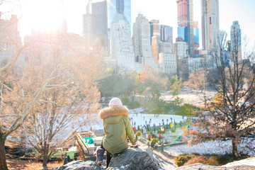 Adorable girl with view of ice-rink in Central Park on Manhattan in New York City