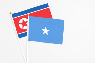 Somalia and North Korea stick flags on white background. High quality fabric, miniature national flag. Peaceful global concept.White floor for copy space.