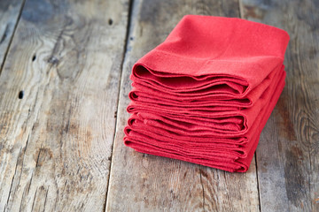 Stack of red linen napkins on wooden background