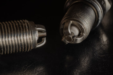 2 car spark plugs on a dark background. View from the side of the electrode. Macro photo. Selective...