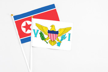 United States Virgin Islands and North Korea stick flags on white background. High quality fabric, miniature national flag. Peaceful global concept.White floor for copy space.