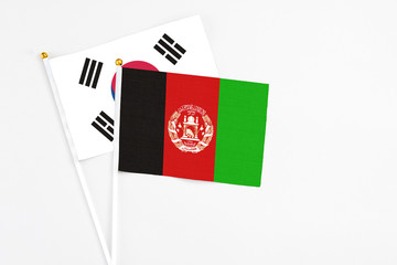 Afghanistan and South Korea stick flags on white background. High quality fabric, miniature national flag. Peaceful global concept.White floor for copy space.