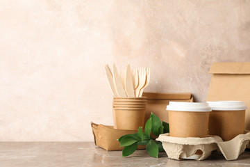 Eco - friendly tableware and paper bag on grey table, space for text