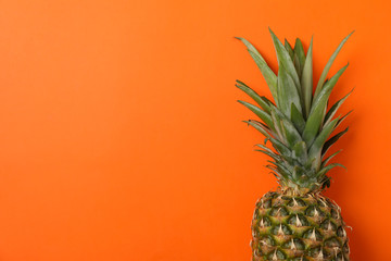 Top of pineapple on orange background, space for text. Juicy fruit