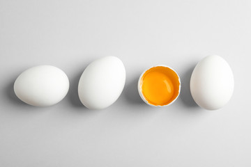 Chicken eggs and half with yolk on white background, space for text