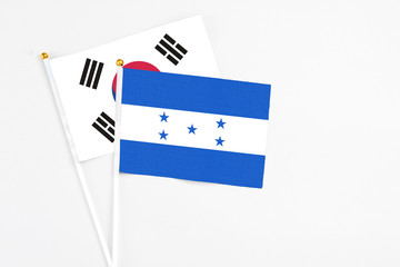 Honduras and South Korea stick flags on white background. High quality fabric, miniature national...