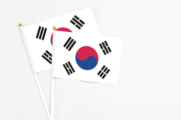 South Korea and South Korea stick flags on white background. High quality fabric, miniature national flag. Peaceful global concept.White floor for copy space.