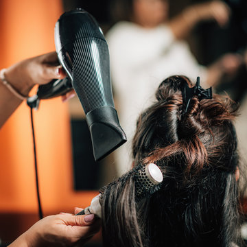 Hairdresser Curling Woman’s Hair.