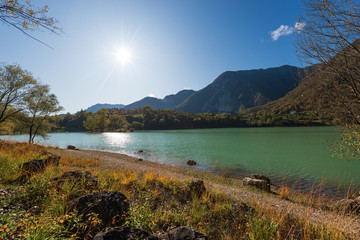 Lago di Tenno in autumn, small beautiful lake in backlight, Italian Alps. Trento province, Trentino-Alto Adige, Italy, Europe