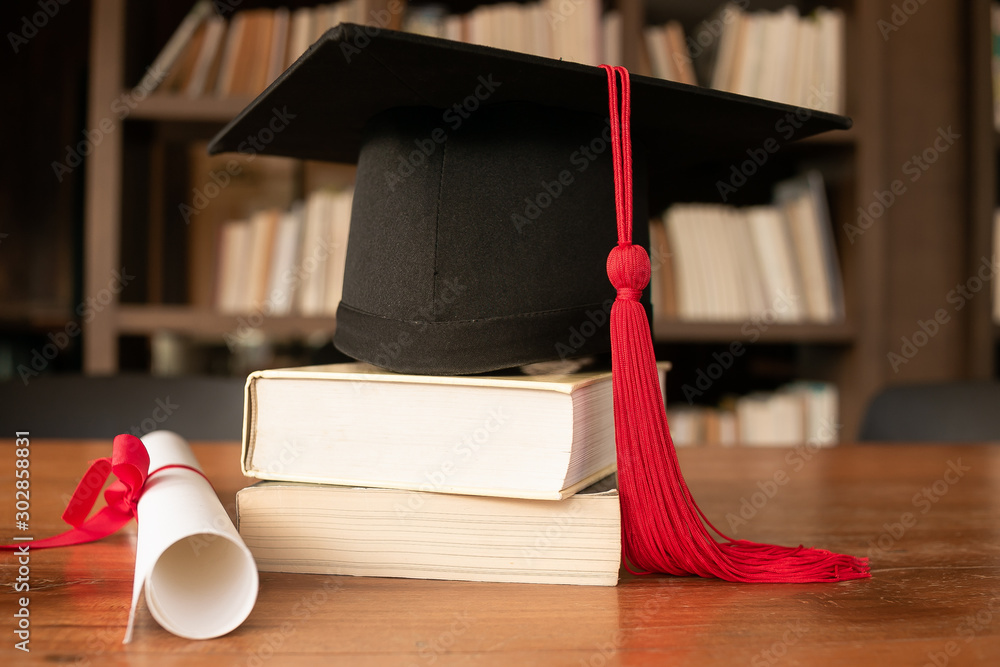 Wall mural graduation cap over open books on wooden background.education concept.graduation day