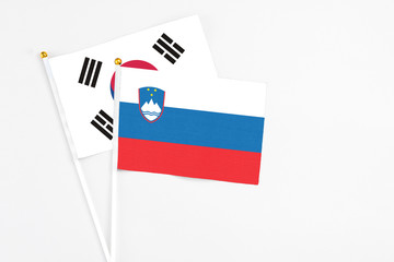 Slovenia and South Korea stick flags on white background. High quality fabric, miniature national flag. Peaceful global concept.White floor for copy space.