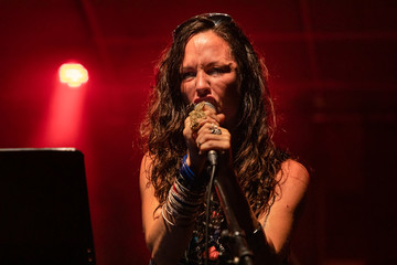 A female musician is viewed from a low angle as she sings with face reactions during a performance...