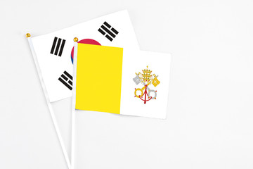 Vatican City and South Korea stick flags on white background. High quality fabric, miniature national flag. Peaceful global concept.White floor for copy space.