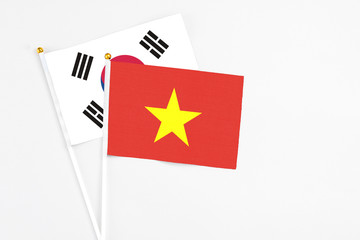 Vietnam and South Korea stick flags on white background. High quality fabric, miniature national flag. Peaceful global concept.White floor for copy space.