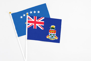 Cayman Islands and Kosovo stick flags on white background. High quality fabric, miniature national flag. Peaceful global concept.White floor for copy space.