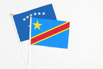 Congo and Kosovo stick flags on white background. High quality fabric, miniature national flag. Peaceful global concept.White floor for copy space.
