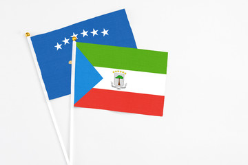 Equatorial Guinea and Kosovo stick flags on white background. High quality fabric, miniature national flag. Peaceful global concept.White floor for copy space.