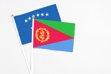 Eritrea and Kosovo stick flags on white background. High quality fabric, miniature national flag. Peaceful global concept.White floor for copy space.