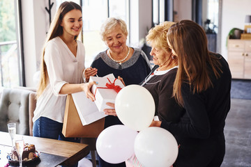 Senior woman with family and friends celebrating a birthday indoors