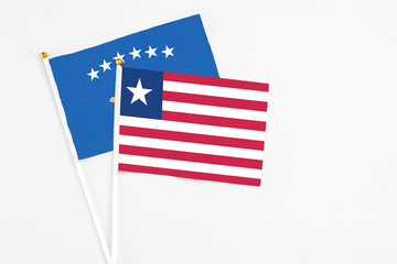 Liberia and Kosovo stick flags on white background. High quality fabric, miniature national flag. Peaceful global concept.White floor for copy space.