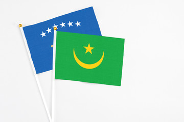 Mauritania and Kosovo stick flags on white background. High quality fabric, miniature national flag. Peaceful global concept.White floor for copy space.