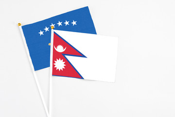 Nepal and Kosovo stick flags on white background. High quality fabric, miniature national flag. Peaceful global concept.White floor for copy space.
