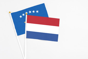 Netherlands and Kosovo stick flags on white background. High quality fabric, miniature national flag. Peaceful global concept.White floor for copy space.