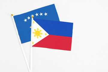 Philippines and Kosovo stick flags on white background. High quality fabric, miniature national flag. Peaceful global concept.White floor for copy space.