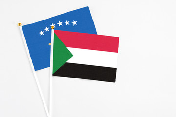 Sudan and Kosovo stick flags on white background. High quality fabric, miniature national flag. Peaceful global concept.White floor for copy space.