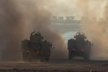 Military chopper and army vehicles flying and driving entering into the smoke and war . Military...