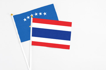 Thailand and Kosovo stick flags on white background. High quality fabric, miniature national flag. Peaceful global concept.White floor for copy space.