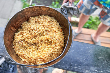 Cauldron with pilaf on a wooden board, top view