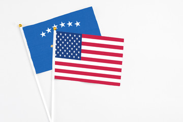 United States and Kosovo stick flags on white background. High quality fabric, miniature national flag. Peaceful global concept.White floor for copy space.