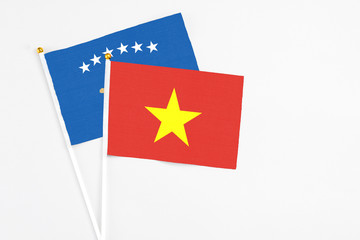 Vietnam and Kosovo stick flags on white background. High quality fabric, miniature national flag. Peaceful global concept.White floor for copy space.