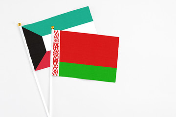 Belarus and Kuwait stick flags on white background. High quality fabric, miniature national flag. Peaceful global concept.White floor for copy space.