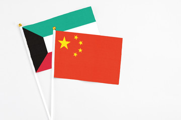 China and Kuwait stick flags on white background. High quality fabric, miniature national flag. Peaceful global concept.White floor for copy space.