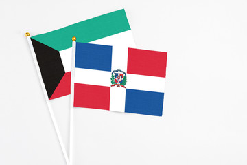 Dominican Republic and Kuwait stick flags on white background. High quality fabric, miniature national flag. Peaceful global concept.White floor for copy space.